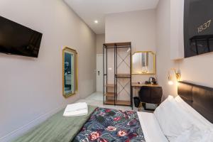 1 dormitorio con 1 cama y escritorio en una habitación en Empire Suites, en Roma