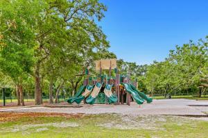 un parque infantil con toboganes en un parque con árboles en Gulf Breeze Getaway, en Gulf Breeze