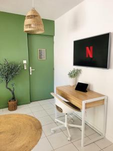 un bureau avec un bureau et une chaise avec un sur le mur dans l'établissement Studio double climatisé avec terrasse - Proche Tram & Centre, à Montpellier