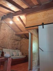 - un salon avec un canapé dans une chambre dotée de plafonds en bois dans l'établissement Ninho do Corvo da Urgueira, à Urgueira