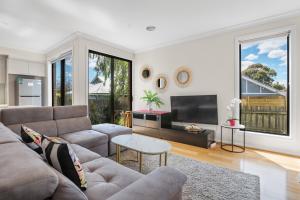 a living room with a couch and a tv at Brand new house near Box Hill in Nunawading