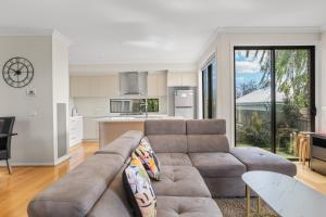 a living room with a couch and a kitchen at Brand new house near Box Hill in Nunawading