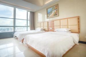 a hotel room with two beds and a large window at Sunny Private Apartment Hotel Of Grand Continental in Guangzhou
