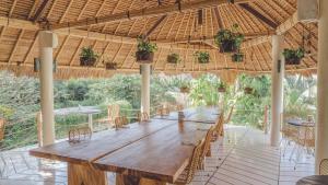 una gran mesa de madera en un pabellón con sillas en The Green Room Canggu en Canggu