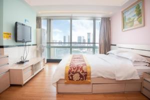 a bedroom with a bed and a large window at Sunny Private Apartment Hotel Of Grand Continental in Guangzhou