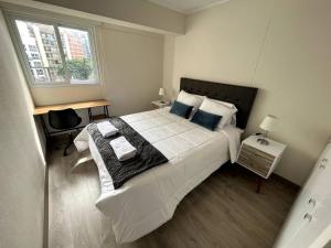 Un dormitorio con una gran cama blanca y una ventana en Luxury apartment in Miraflores with rooftop pool, en Lima