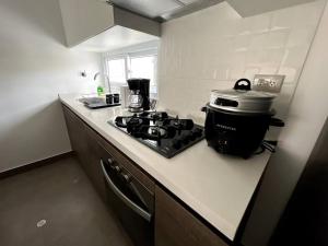 La cocina está equipada con fogones y encimera con fogones. en Luxury apartment in Miraflores with rooftop pool, en Lima