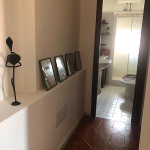 een badkamer met een toilet en een aantal foto's aan de muur bij Casa las Molas in La Maddalena