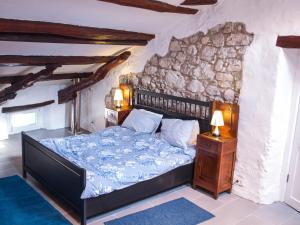 a bedroom with a bed and a stone wall at Apartments Hemingway House in Kobarid
