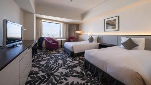 a hotel room with two beds and a flat screen tv at ANA Crowne Plaza Hotel Grand Court Nagoya, an IHG Hotel in Nagoya
