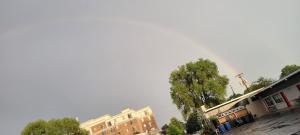 eine Stadtstraße mit Gebäuden und einem Regenbogen am Himmel in der Unterkunft Crestwood Motel in Burlington