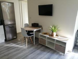 a kitchen with a desk and a table and a refrigerator at Cantinho da Karine in Maia