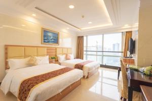 Habitación de hotel con 2 camas y escritorio en Sunny Private Apartment Hotel Of Grand Continental, en Guangzhou