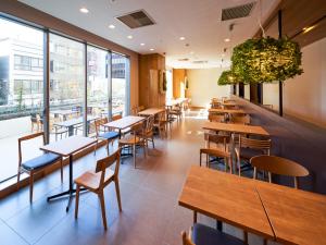 a restaurant with tables and chairs and windows at Super Hotel Premier Akasaka in Tokyo
