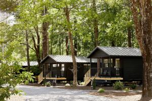una cabaña negra en el bosque con árboles en AutoCamp Catskills, en Saugerties