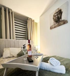 um quarto com uma mesa com dois copos e uma garrafa de vinho em Fabulous Fiery Flat w/ body shower - Tylorstown em Llwyn-y-pia