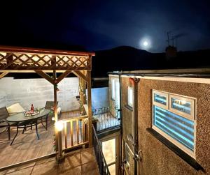 a view of a deck with a table and a patio at Fabulous Fiery Flat w/ body shower - Tylorstown in Llwyn-y-pia