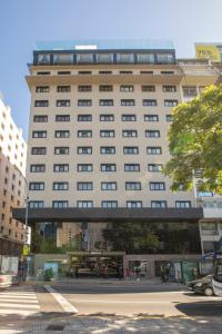 un gran edificio con una pasarela delante de él en El Misti Coliving Obelisco en Buenos Aires