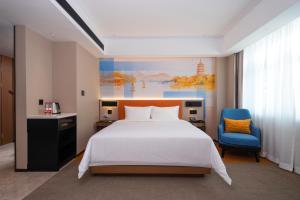 Hampton by Hilton Hangzhou West Lake في هانغتشو: غرفة نوم بسرير كبير وكرسي ازرق