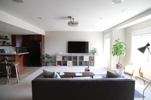 a living room with a couch and a tv at Yucca Tree-Licensed in Kelowna