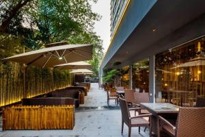 um restaurante com mesas, cadeiras e guarda-sóis em Hampton by Hilton Hangzhou West Lake em Hangzhou