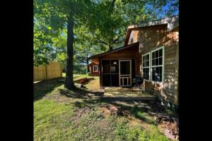 una pequeña casa con porche y patio en The Hideaway at Bear Mountain Log Cabins en Eureka Springs