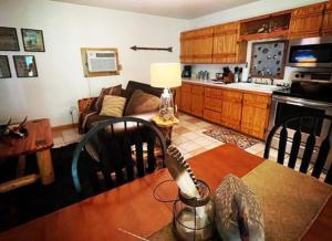 cocina y sala de estar con mesa y sofá en The Hideaway at Bear Mountain Log Cabins en Eureka Springs