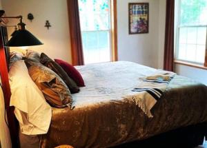 a bedroom with a bed with pillows and a lamp at The Hideaway at Bear Mountain Log Cabins in Eureka Springs