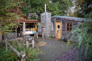 eine kleine Holzhütte mit Spielhaus in der Unterkunft Charming 2-Bed Cabin in Sutton Coldfield in Sutton Coldfield