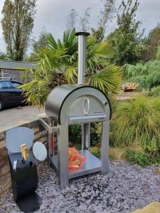 a pizza oven sitting on top of a pile of rocks at Charming 2-Bed Cabin in Sutton Coldfield in Sutton Coldfield