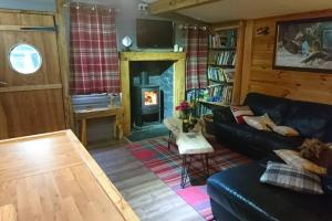 a living room with a couch and a fireplace at Charming 2-Bed Cabin in Sutton Coldfield in Sutton Coldfield
