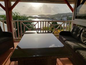 salon z kanapą i stołem na balkonie w obiekcie Villa Nautilia , vue mer, proche plage w mieście Les Trois-Îlets