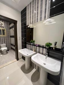 a bathroom with two sinks and a shower at Loft 16 in Jeddah