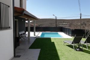 um quintal com piscina, cadeiras e relva em Casas do Bernardo em Ferral