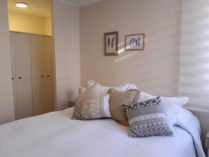 Un dormitorio con una cama con almohadas. en Chillan Centro en Chillán