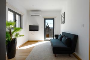 uma sala de estar com um sofá preto e uma televisão em Casas do Bernardo em Ferral