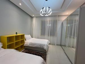 a bedroom with two beds and a yellow cabinet at Loft 16 in Jeddah