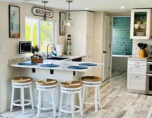 eine Küche mit einer Theke mit Hockern in der Unterkunft Seaside Serenity Cottage in Shelburne