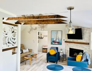 ein Wohnzimmer mit blauen Stühlen und einem Kamin in der Unterkunft Seaside Serenity Cottage in Shelburne