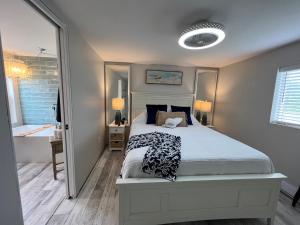 ein Schlafzimmer mit einem Bett und ein Badezimmer mit einer Badewanne in der Unterkunft Seaside Serenity Cottage in Shelburne