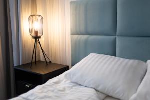 a bedroom with a bed and a lamp on a night stand at Moon Apartments Gdańsk in Gdańsk