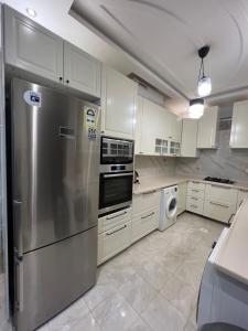 a kitchen with a stainless steel refrigerator and a dishwasher at Loft 16 in Jeddah +23 photos