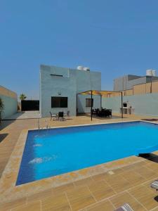 a large blue swimming pool in front of a building at Al Andalus Chalets ‏ in Shūnat Nimrīn