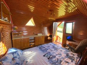 um quarto com uma cama num quarto de madeira em Căbănuță rustică 02 em Băniţa