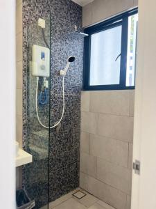 La salle de bains est pourvue d'une douche avec une porte en verre. dans l'établissement KK CITY CENTRE 800mbps Unifi,Cuckoo INFINITY POOL STUDIO ROOM, à Kota Kinabalu