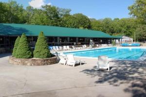 a swimming pool with chairs and a building at River Run Cottage Modern 2BR Waterfront Retreat in Linville Land Harbor in Newland