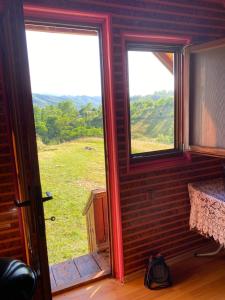 a room with two windows and a view of a field at Căbănuță rustică 02 in Băniţa