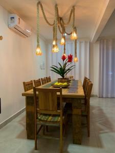 una sala da pranzo con tavolo e sedie in legno di Casa incrível em condomínio - Arraial d'Ajuda a Arraial d'Ajuda