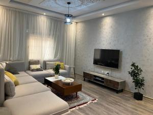 Loft 16 في جدة: غرفة معيشة مع أريكة وتلفزيون بشاشة مسطحة