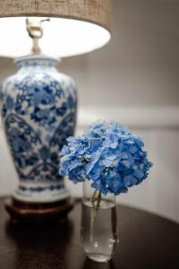 a vase with blue flowers and a lamp on a table at Beechwood Inn in Clayton